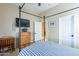 A well-lit bedroom featuring a four poster bed with blue bedding, a dresser, and wall-mounted television at 2567 E San Isido Trl, Casa Grande, AZ 85194