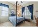 A bedroom featuring a four poster bed, blue bedding, and blue curtains, with a window at 2567 E San Isido Trl, Casa Grande, AZ 85194