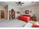 Bright bedroom with a ceiling fan, a bookshelf, and a comfortable bed with an orange comforter at 2567 E San Isido Trl, Casa Grande, AZ 85194