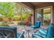 Inviting covered patio with comfortable blue chairs and a view of the lush backyard at 2567 E San Isido Trl, Casa Grande, AZ 85194
