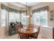 Cozy dining nook with a wooden table, four chairs, a bright window, and a decorative window valance at 2567 E San Isido Trl, Casa Grande, AZ 85194