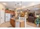Open kitchen featuring an island with a sink, white appliances, and an open view to the living room at 2567 E San Isido Trl, Casa Grande, AZ 85194