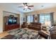 Comfortable living room with a ceiling fan, large windows, and leather furniture, perfect for relaxation at 2567 E San Isido Trl, Casa Grande, AZ 85194