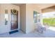 Cozy covered porch area with seating, front door with wreath, and a decorative side window at 2567 E San Isido Trl, Casa Grande, AZ 85194