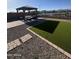 Landscaped backyard with gazebo, artificial grass, and stone accents for outdoor entertaining at 25968 W Tina Ln, Buckeye, AZ 85396