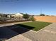 Backyard featuring artificial turf, gravel landscaping, and a wrought iron fence at 25968 W Tina Ln, Buckeye, AZ 85396