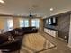 Comfortable living room with a modern TV console, a large sectional, and sliding glass doors at 25968 W Tina Ln, Buckeye, AZ 85396