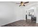 Neutral-toned living room featuring tile flooring and a ceiling fan, with a glimpse into the kitchen at 26264 N 74Th Ln, Peoria, AZ 85383