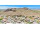 High-angle shot showcases homes, desert surroundings, and a majestic mountain backdrop at 27562 N 99Th Dr, Peoria, AZ 85383