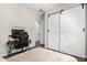 Bedroom featuring white sliding barn doors, wood-look tile flooring, and stylish decor at 27562 N 99Th Dr, Peoria, AZ 85383