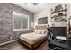 Bedroom with accent brick wall, wood-look tile flooring, and modern decor at 27562 N 99Th Dr, Peoria, AZ 85383