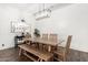 Bright dining room with wood-look floors, rustic table, modern light fixture and white shiplap walls at 27562 N 99Th Dr, Peoria, AZ 85383