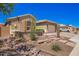 Inviting home exterior showcasing a well-kept desert landscape and a charming facade at 27562 N 99Th Dr, Peoria, AZ 85383
