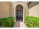 Welcoming front entryway with an arched doorway and manicured green bushes at 27562 N 99Th Dr, Peoria, AZ 85383