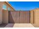 Wooden gate with brick columns and a secure entrance on a paved surface at 27562 N 99Th Dr, Peoria, AZ 85383