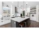 Modern eat-in kitchen with white cabinets, stainless steel appliances, and a large center island at 27562 N 99Th Dr, Peoria, AZ 85383