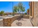 Cozy outdoor patio with stone wall and two chairs at 27562 N 99Th Dr, Peoria, AZ 85383