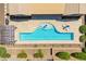 Aerial view of a modern backyard pool featuring stone decking and lush landscaping at 27562 N 99Th Dr, Peoria, AZ 85383