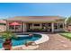 Beautiful backyard with pebble stone, a sparkling pool, putting green and covered patio at 29816 N 51St Pl, Cave Creek, AZ 85331