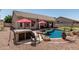 Backyard with pebble stone, hot tub, pool with rock feature and covered patio at 29816 N 51St Pl, Cave Creek, AZ 85331