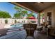 Outdoor covered patio overlooking backyard pool, rock waterfall, and ample seating areas at 29816 N 51St Pl, Cave Creek, AZ 85331