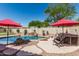 Backyard pool and hot tub area with red umbrellas, rock features and putting green at 29816 N 51St Pl, Cave Creek, AZ 85331