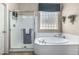 Bathroom with jacuzzi tub, glass enclosed shower and frosted glass windows at 29816 N 51St Pl, Cave Creek, AZ 85331