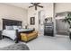 Bright bedroom with a dark wood bed, yellow bench, and decor, next to an doorway to a bathroom at 29816 N 51St Pl, Cave Creek, AZ 85331