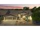 Inviting front exterior featuring a well-manicured yard and a convenient three-car garage with a sunset at 29816 N 51St Pl, Cave Creek, AZ 85331
