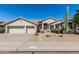 Inviting front exterior featuring a well-manicured yard and a convenient three-car garage at 29816 N 51St Pl, Cave Creek, AZ 85331