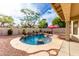 A tranquil backyard pool with waterfall, rock features, and lush landscaping with cozy seating area at 29816 N 51St Pl, Cave Creek, AZ 85331