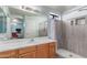 Bright bathroom featuring a tiled walk-in shower, a light wood vanity, a large mirror and updated fixtures at 3018 W Country Club Ter, Phoenix, AZ 85027