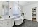 Bright and airy bathroom with soaking tub, dual sinks, modern lighting, and tiled floors at 3038 E Longhorn Dr, Gilbert, AZ 85297