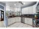 Well-lit kitchen featuring stainless steel appliances, white cabinets, granite countertops, and open view to living area at 34611 N Sunset Trl, Cave Creek, AZ 85331