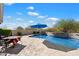 Beautiful pool area with an umbrella table, built-in water feature, desert landscape, and plenty of room for lounging at 34611 N Sunset Trl, Cave Creek, AZ 85331