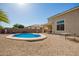 Enjoy a private backyard pool area with beige gravel landscaping and a covered patio at 36179 W Cartegna Ln, Maricopa, AZ 85138