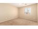 Bright bedroom with a large window offering natural light and neutral walls complementing the carpet at 36179 W Cartegna Ln, Maricopa, AZ 85138