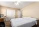 Cozy bedroom featuring carpeted floors, closet, ceiling fan, and a queen-sized bed with a comfortable white comforter at 36179 W Cartegna Ln, Maricopa, AZ 85138