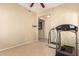 Neutral room featuring tiled floors, a ceiling fan, and a door leading to another room at 36179 W Cartegna Ln, Maricopa, AZ 85138