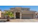 Inviting home exterior featuring desert landscaping and a two-car garage at 36179 W Cartegna Ln, Maricopa, AZ 85138
