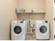 Laundry room featuring modern washing machines and a shelf for storage, creating a functional space at 36179 W Cartegna Ln, Maricopa, AZ 85138
