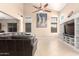 A spacious living room with a high ceiling, ceiling fan, and a built-in entertainment center at 36179 W Cartegna Ln, Maricopa, AZ 85138
