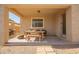 Covered patio with a wooden dining table, bench, and chairs offering an ideal space for outdoor entertaining at 36179 W Cartegna Ln, Maricopa, AZ 85138