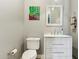 A neutral-toned half bathroom with a modern vanity, white toilet, and framed mirror at 3817 E Patrick Ln, Phoenix, AZ 85050