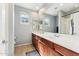 Bright bathroom featuring dual sinks, tile floors, and a large mirror, offering a stylish and functional space at 3817 E Patrick Ln, Phoenix, AZ 85050