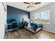Nice bedroom features wood-style flooring and a dark blue accent wall, perfect for relaxation at 3817 E Patrick Ln, Phoenix, AZ 85050