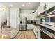 A spacious kitchen with stainless steel appliances, white cabinetry, a stylish subway tile backsplash, and granite countertops at 3817 E Patrick Ln, Phoenix, AZ 85050