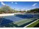 A pristine tennis court with clear markings, surrounded by well-maintained landscaping and lighting at 3817 E Patrick Ln, Phoenix, AZ 85050