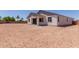 Expansive dirt backyard with views of the house and palm trees at 40595 W Michaels Dr, Maricopa, AZ 85138