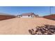 Backyard with dirt ground and views of the house, featuring a privacy wall at 40595 W Michaels Dr, Maricopa, AZ 85138